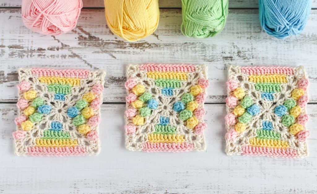 crocheted granny square in rainbow colors with puff stitches
