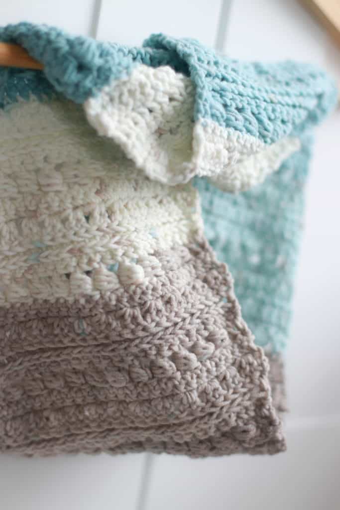 Crochet stitches in cream, blue and beige. 