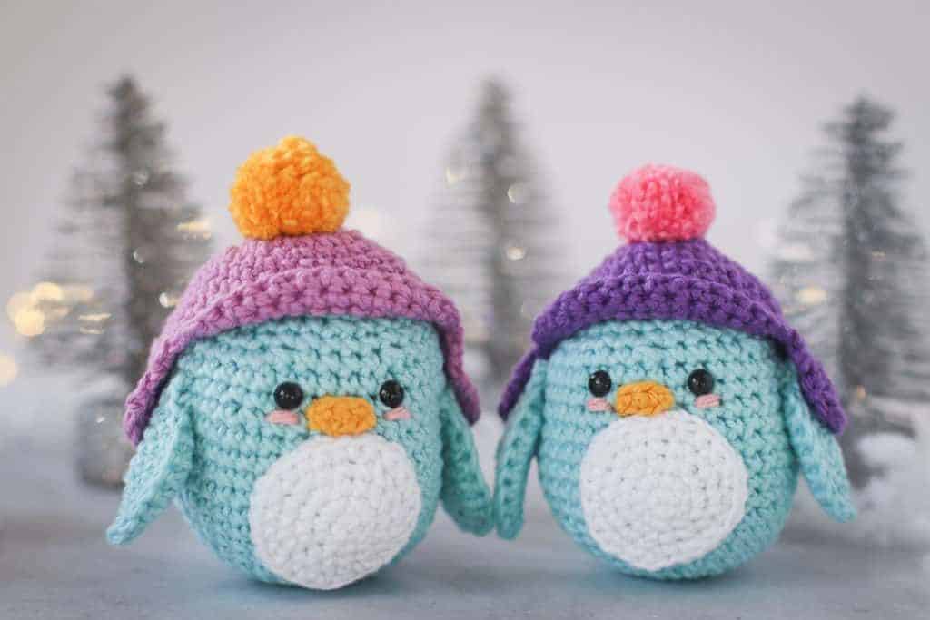 crochet penguin wearing purple snow hats