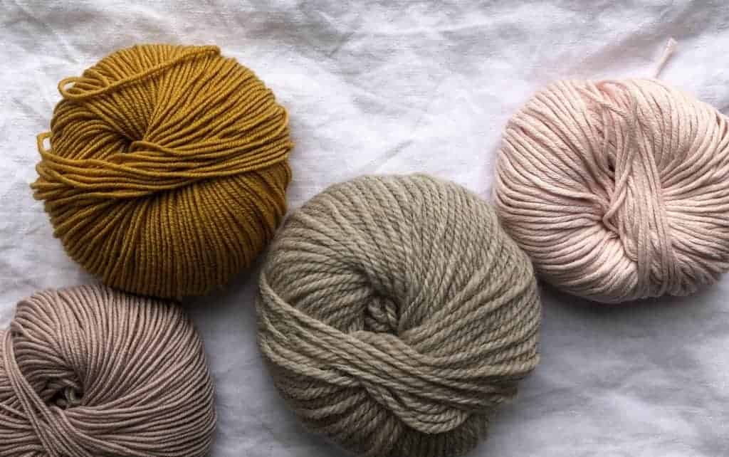 Different color yarns on a white fabric background