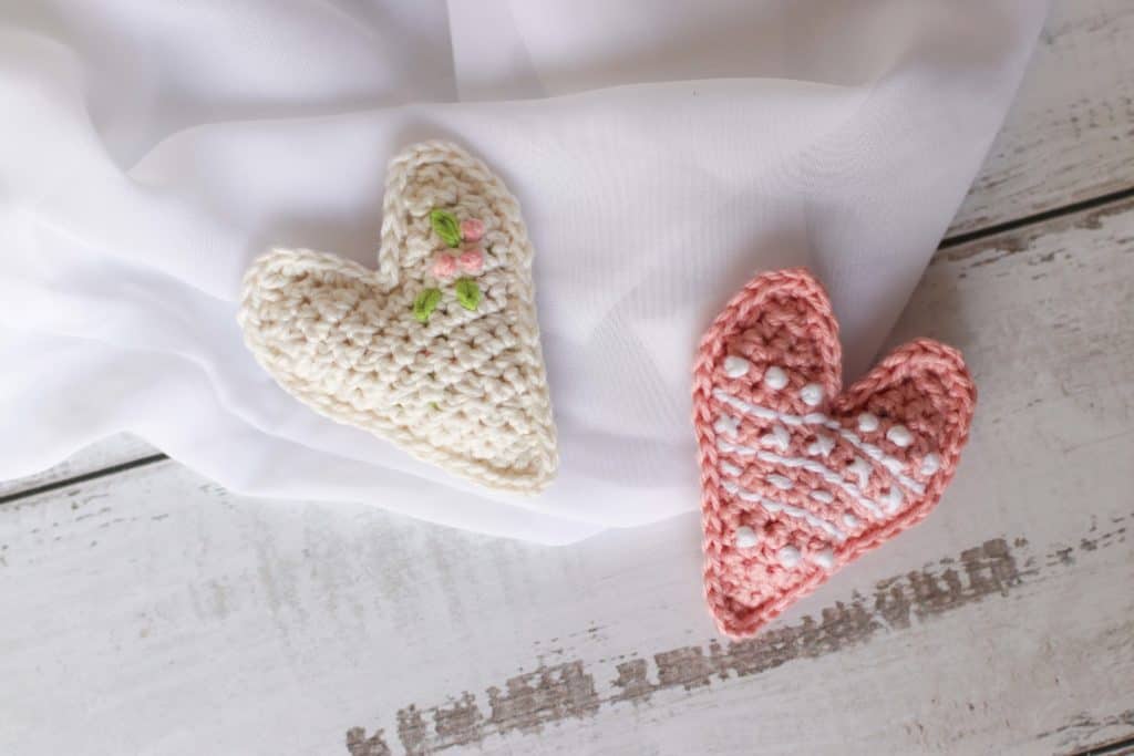 Two crochet hearts with embroidery details 