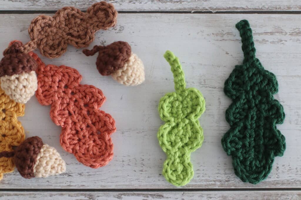 crochet acorns and crochet oak leaves on a textured wooden background | autumn crochet pattern | 